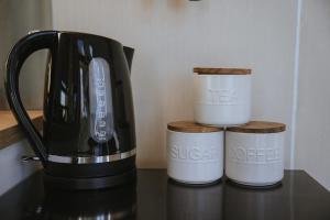 a coffee maker and three cups on a table at Tallarook Hilltop Tiny House 1 by Tiny Away in Tallarook +15 photos