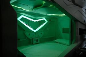 a room with a green neon sign on the wall at Nap Junction in Pune