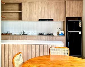 a kitchen with a table and a black refrigerator at SanSan Home in Jimbaran
