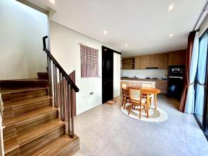 a kitchen and dining room with a table and stairs at SanSan Home in Jimbaran