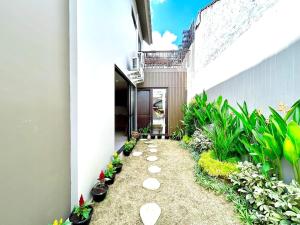 a walkway in the middle of a building with plants at SanSan Home in Jimbaran +5 photos