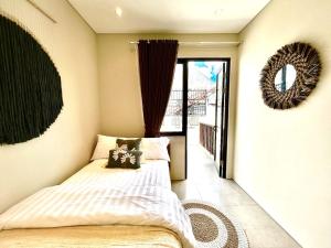a bedroom with a bed and a mirror on the wall at SanSan Home in Jimbaran