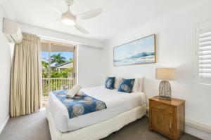 a white bedroom with a bed and a window at Osprey Apartments in Mooloolaba +180 photos