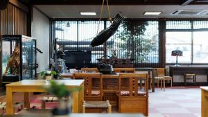 a restaurant with tables and chairs and a television at 緑風苑 きよはる Ryokufuen Kiyoharu in Takayama