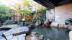 a pool of water with rocks in a backyard at 緑風苑 きよはる Ryokufuen Kiyoharu in Takayama
