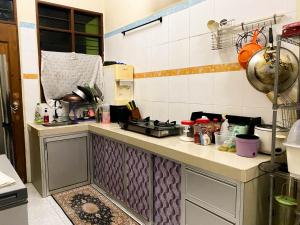 a kitchen with a stove and a counter top at Azihar Homestay Marang in Marang