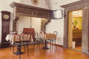 a dining room with a table and chairs and a clock at Hotel Centrale in Viterbo
