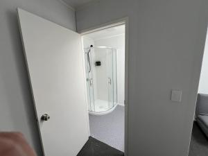 a bathroom with a shower and a glass door at Vienna Motel in Paihia