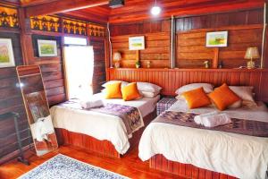 two beds in a room with wooden walls at Pondok Panglima Awang in Pantai Cenang +41 photos
