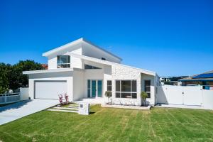 a white house with a green yard at 2 Ulmarra in Manning Point