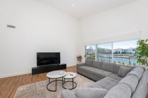 a living room with a couch and a tv at 2 Ulmarra in Manning Point