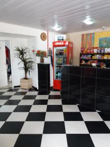ein Geschäft mit einer Soda-Maschine und einem karierten Boden in der Unterkunft Porto Seguro Hotel - Porto Velho in Porto Velho