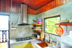 a kitchen with a sink and a stove and a window at Pondok Panglima Awang in Pantai Cenang