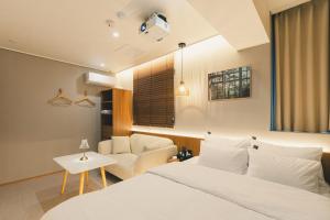 a bedroom with a bed and a couch and a chair at 부평 이상한호텔 in Pup'yŏng-yŏk