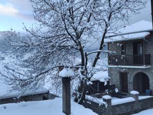 a street light covered in snow next to a tree at Metsovo Fireplace Retreat I in Metsovo