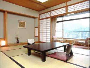 a room with a table and chairs and a large window at Hyoe Koyokaku in Kobe