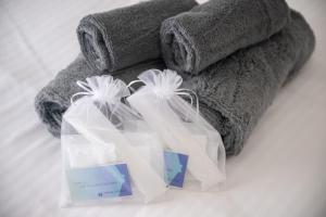 two white shopping bags sitting next to a towel at Hotel HIRAKU RYUKYU -STYLE- in Naha +227 photos