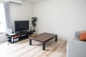 a living room with a coffee table and a flat screen tv at The Emu Park Tomiyoshi in Kanie +48 photos