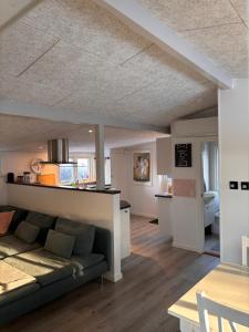 a living room with a couch and a kitchen at Glentevej idyl in Assens