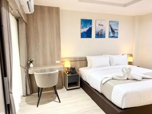 a hotel room with a bed with a swan on it at Indigo Hotel Hatyai 2 Khet 8 in Sathani Hat Yai