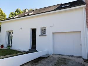 a white house with a garage at Chantilly in Orvault