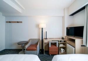 a hotel room with a bed and a desk and a tv at Smile Hotel Tokyo Asagaya in Tokyo +29 photos