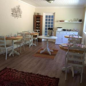 una habitación con mesas y sillas y una cocina en Passagem da Neblina - Bed & Breakfast, en Campos do Jordão