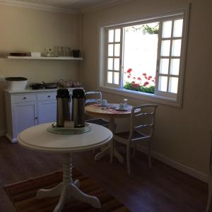 カンポス・ド・ジョルドンにあるPassagem da Neblina - Bed & Breakfastの窓、テーブル付きのキッチンが備わります。