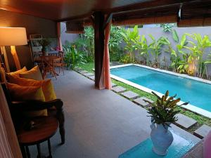 a swimming pool in a room with a table and chairs at Sanur Backpacker Room Bali in Sanur +19 photos