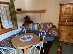 a living room with a couch and a table with a teddy bear at Cottage Grundschera Engadin in Brail +2 photos
