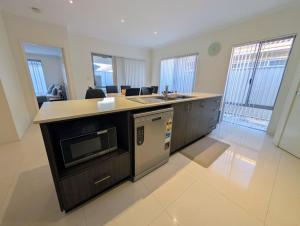 a kitchen with a sink and a microwave at Grand stay in Perth