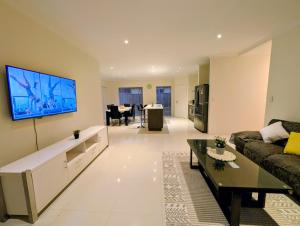 a living room with a couch and a tv on a wall at Grand stay in Perth