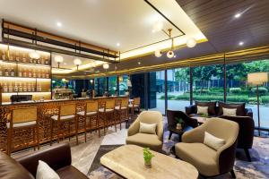 a restaurant with a bar with chairs and tables at Ascott Menteng Jakarta in Jakarta