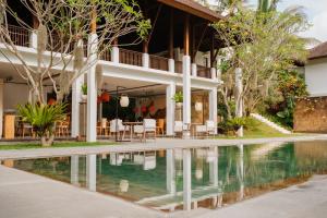 an external view of a villa with a swimming pool at Bumi Kinar Heritage in Ubud