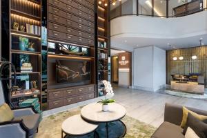 a lobby with a table and chairs and a tv at Ascott Menteng Jakarta in Jakarta