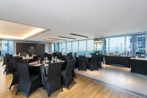 a restaurant with black tables and black chairs at Ascott Menteng Jakarta in Jakarta +50 photos