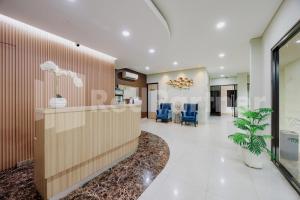 an office lobby with a reception desk and blue chairs at Hotel Gandamanah Mitra RedDoorz in Bekasi