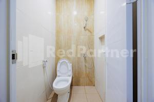 a bathroom with a toilet and a shower at Hotel Gandamanah Mitra RedDoorz in Bekasi +28 photos