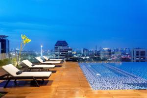 a row of lounge chairs on the roof of a building at Ascott Menteng Jakarta in Jakarta
