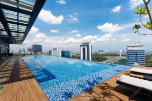 a swimming pool on the roof of a building with a city at Ascott Menteng Jakarta in Jakarta