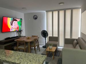a living room with a couch and a table and a tv at Alameda del rio Turpial in Barranquilla