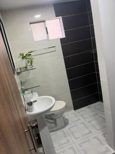 a bathroom with a toilet and a sink at Alameda del rio Turpial in Barranquilla +17 photos