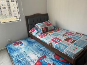 a bed with a quilt on it in a bedroom at Alameda del rio Turpial in Barranquilla