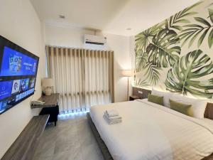 a bedroom with a large white bed and a tv at Tree Airport Hotel Hatyai in Hat Yai Intl