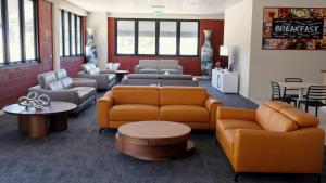 a waiting room with couches and chairs and tables at Gallery Boutique Hotel in Fremantle