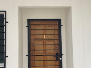 a wooden door in a room with a white wall at Rugani Homestay in Papar +4 photos