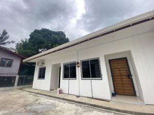 a white building with two doors on it at Rugani Homestay in Papar
