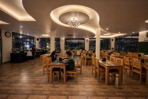 two people sitting at tables in a restaurant at Riverline Gold Resort in Rishīkesh