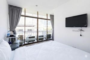 a bedroom with a bed and a flat screen tv at Rest Inn Silom - BTS Chong Nonsi in Bang Rak