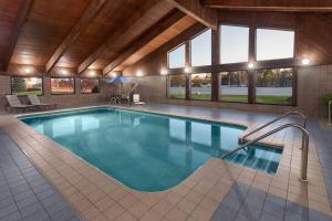 a large swimming pool in a large building with at AmericInn by Wyndham Green Bay West in Green Bay